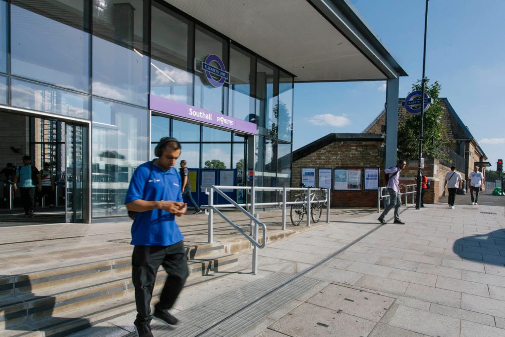 A man in a blue shirt is walking down the steps of a building.